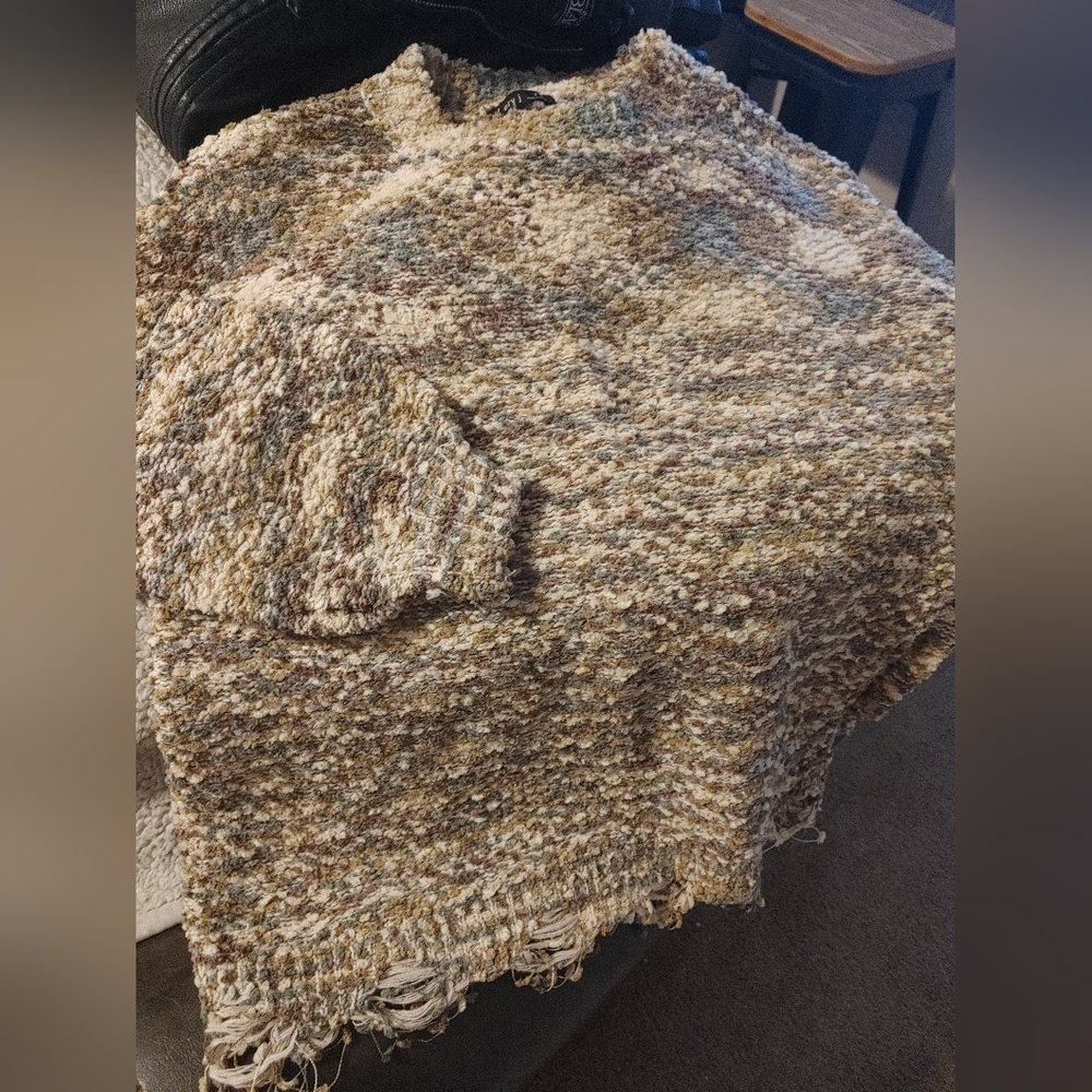 Multicolor sweater with distressed bottom.